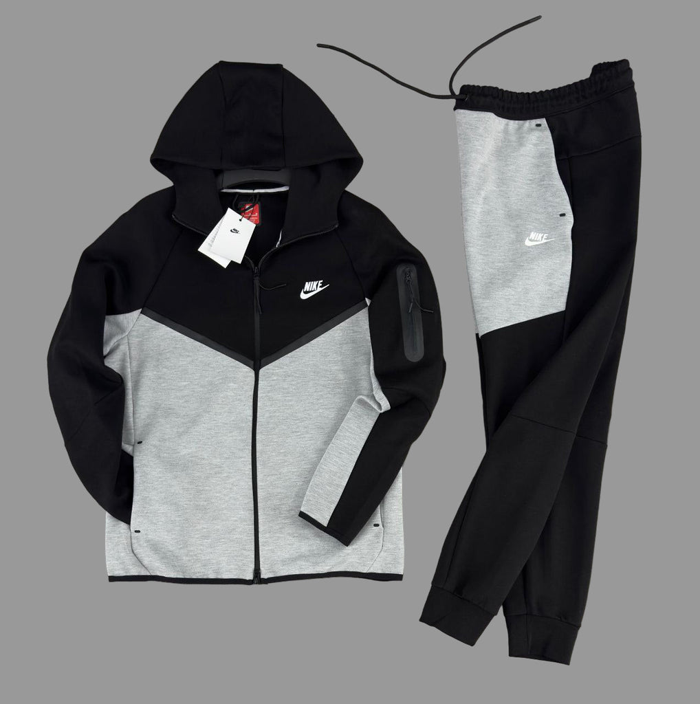 Férfi Nike Tech Fleece melegítőruha, fekete és klasszikus szürke színben, fekete csíkokkal és fehér logós ujjzsebbel.